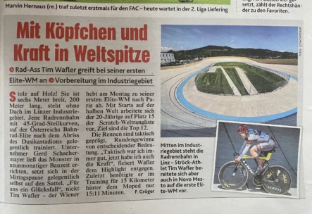 Ein deutscher Zeitungsartikel mit einem Foto eines Freiluft-Velodroms und einem Radfahrer in Rennkleidung auf einem Rennrad. Die Überschrift lautet "Mit Köpfchen und Kraft in Weltspitze" in großer roter und oranger Schrift.