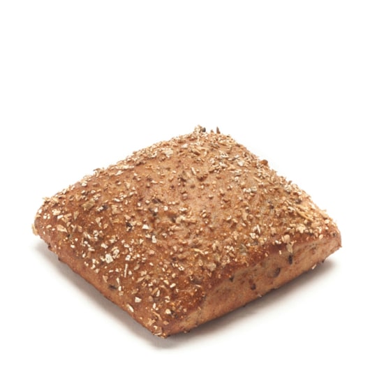 Ein quadratisches, mit Haferflocken belegtes Vollkornbrötchen steht auf einem weißen Hintergrund.