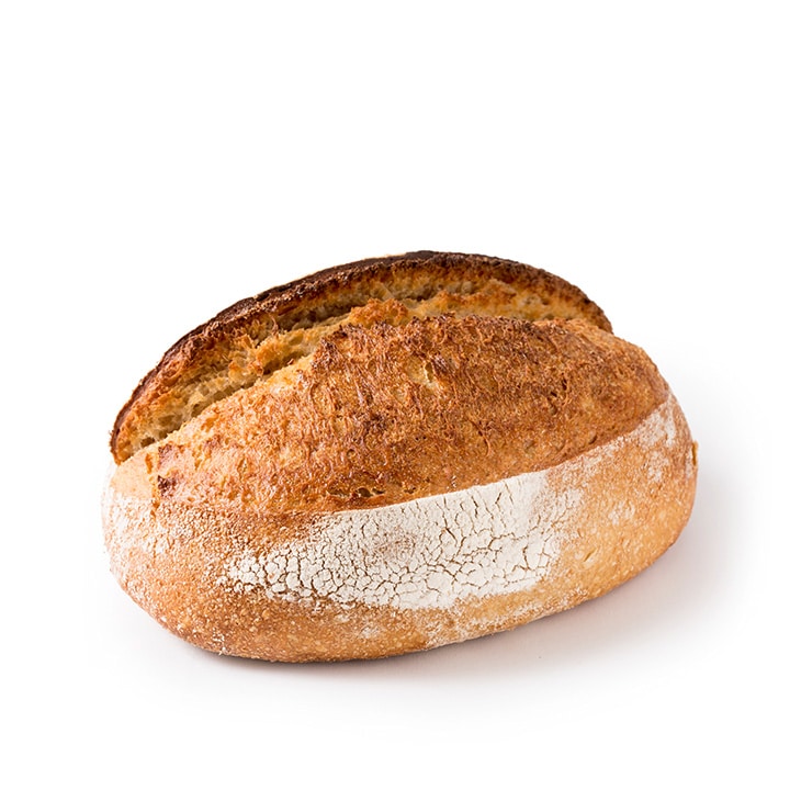 Ein runder, rustikaler, handwerklich hergestellter Brotlaib mit einer goldbraunen Kruste und einem Hauch von Mehl auf der Oberfläche, vor einem weißen Hintergrund.