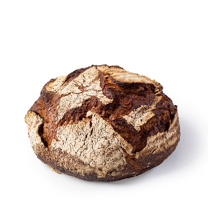 Ein runder, rustikaler, handwerklich hergestellter Brotlaib mit einer dunklen, knusprigen Außenseite und einer Mehlschicht auf der Oberseite auf einem weißen Hintergrund.
