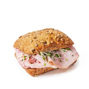 Ein entkörntes Vollkornsandwichbrötchen, gefüllt mit Schinkenscheiben, belegt mit geraspeltem Salat und gehacktem Schnittlauch, auf einem schlichten weißen Hintergrund.