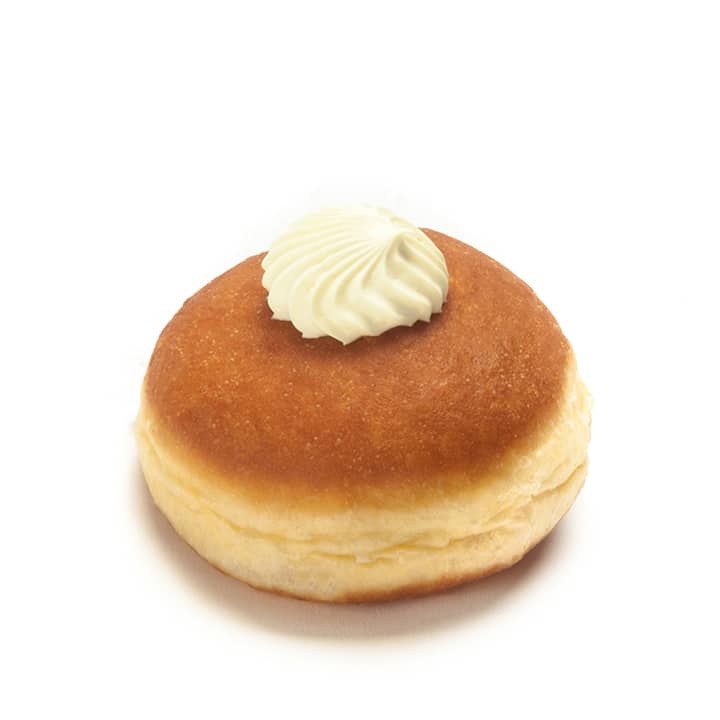Ein runder, goldbrauner Krapfen mit einem Strudel aus weißer Sahne auf der Oberseite, vor einem schlichten weißen Hintergrund.