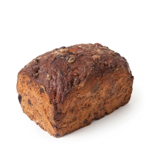 Ein Laib dunkles Vollkornbrot mit einer rauen, strukturierten Kruste und sichtbaren Körnern auf einem weißen Hintergrund.