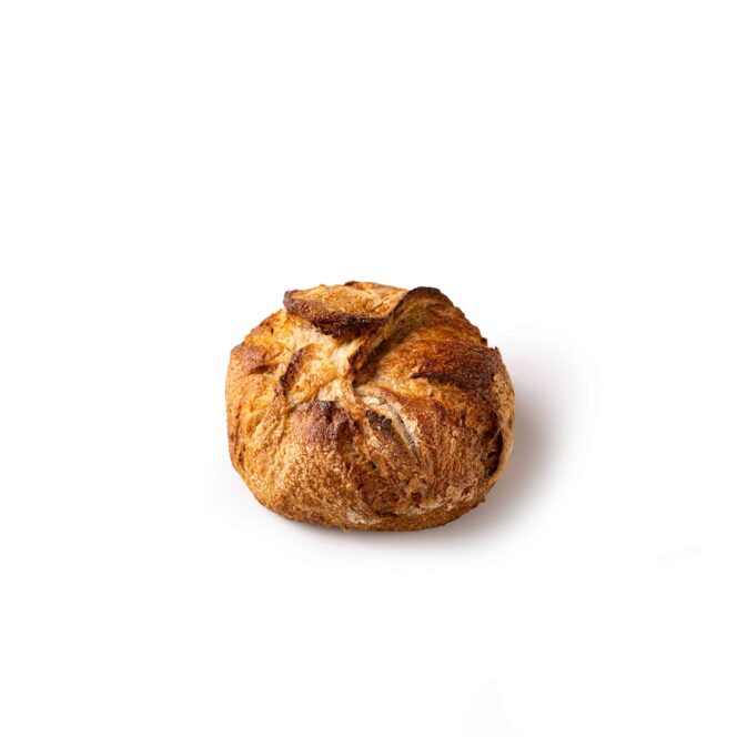 Ein runder, rustikaler Laib Brot mit goldbrauner, knuspriger Kruste auf einem schlichten weißen Hintergrund.