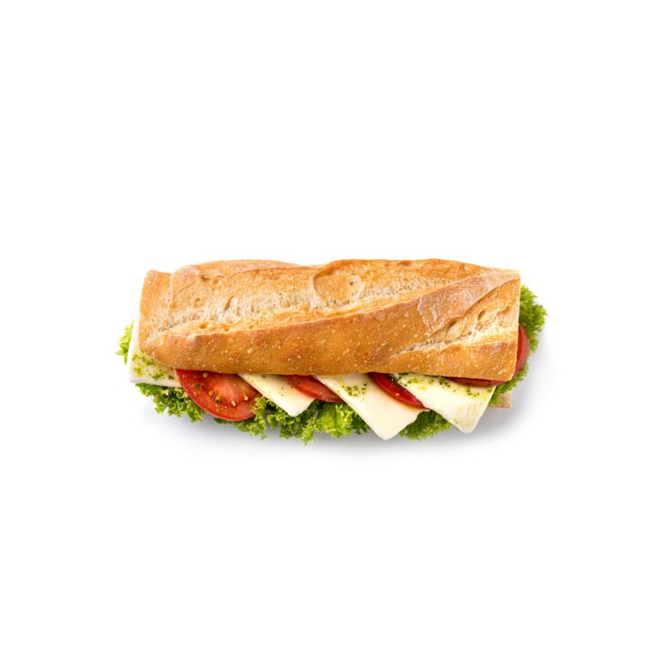 Ein frisches Sandwich auf einem Baguette mit grünem Blattsalat, Tomatenscheiben und weißen Käsescheiben, fotografiert auf einem weißen Hintergrund.