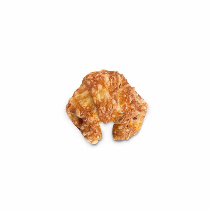 Ein kleines, goldbraunes Croissant mit einer flockigen Textur, fotografiert auf einem schlichten weißen Hintergrund.