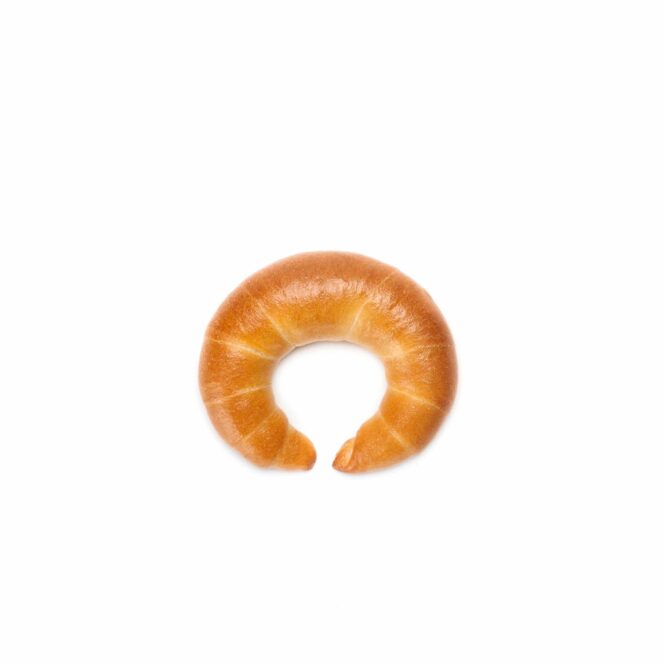 Ein einzelnes goldbraunes, halbmondförmiges Croissant ist auf einem schlichten weißen Hintergrund platziert.