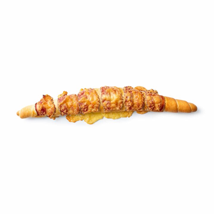 Eine goldbraune, gebackene Brotstange, belegt mit geschmolzenem Käse und Schinkenstückchen, isoliert auf einem weißen Hintergrund.