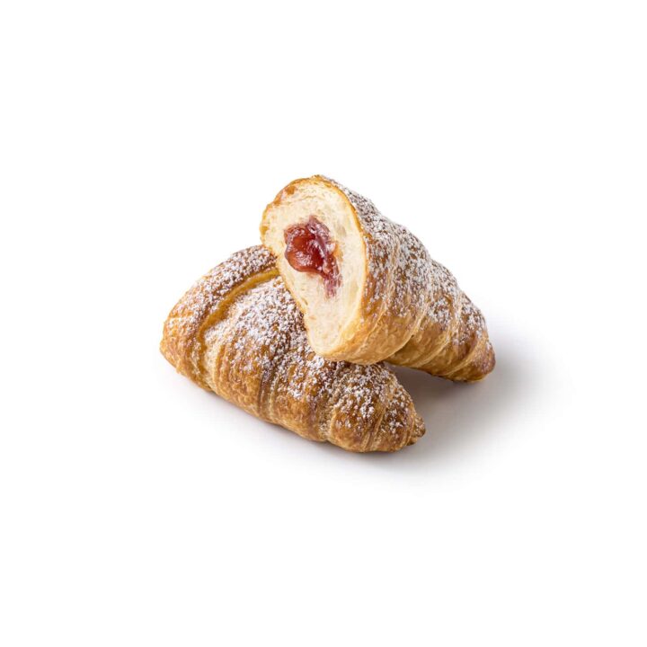 Zwei mit Puderzucker bestreute Croissants, von denen eines aufgeschnitten ist, um eine rote Fruchtfüllung freizulegen, auf weißem Hintergrund.