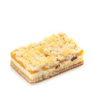 Ein rechteckiges Stück Streuselkuchen mit einer geschichteten Füllung, einschließlich gelber Fruchtstücke und Streusel, dargestellt auf weißem Hintergrund.