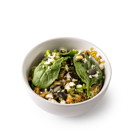 Eine weiße Schale, gefüllt mit Quinoa-Salat, mit Babyspinatblättern, zerbröckeltem Fetakäse, Kürbiskernen und gehacktem Gemüse. Auf dem Rand der Schale steht das Wort Fuel.