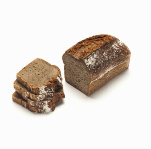 Ein Laib dunkles Roggenbrot mit einer knusprigen Oberseite ist teilweise aufgeschnitten, wobei vier Scheiben neben dem verbleibenden ungeschnittenen Teil gestapelt sind, alles auf weißem Hintergrund.