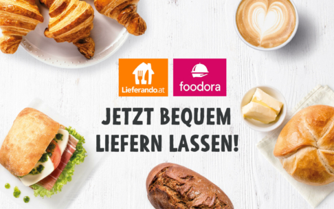 Frühstücksspeisen wie Croissants, ein Sandwich, ein Brötchen, ein Milchkaffee mit herzförmigem Schaum und Butter umgeben Logos für Lieferando.at und foodora über dem Text "JETZT BEQUEM LIEFERN LASSEN!".