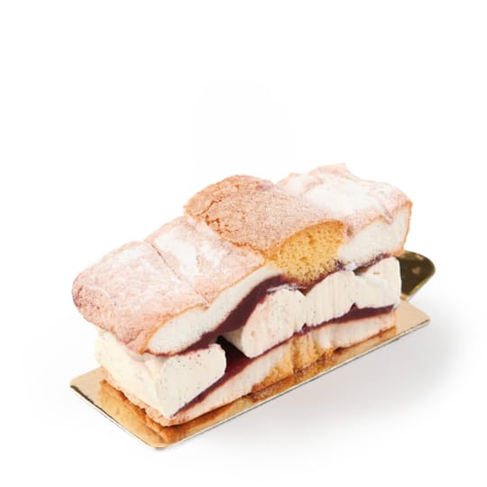 Ein Dessert mit Schichten aus weichem Biskuit, bestäubt mit Puderzucker, gefüllt mit Vanillecreme und einer Schicht aus dunkler Fruchtmarmelade, serviert auf einem kleinen goldenen Tablett vor weißem Hintergrund.
