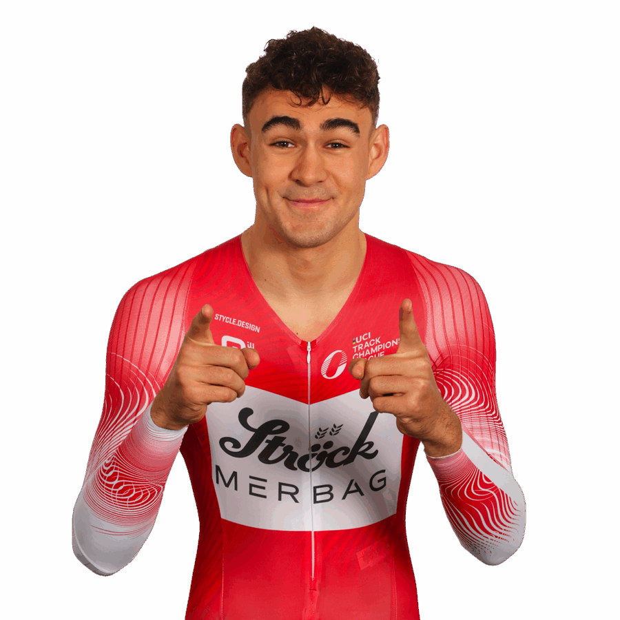 Ein männlicher Radfahrer in einem rot-weißen Anzug mit Sträck MERBAG-Branding steht vor einem weißen Hintergrund, lächelt und zeigt mit beiden Zeigefingern in die Kamera.