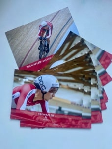Ein Postkartenset zum Thema Radsport zeigt einen Athleten in rot-weißer Kleidung mit der Aufschrift "Tim Wafler", der auf einem Fahrrad in einem Velodrom sitzt, und einen Text, der seine Leistungen hervorhebt.