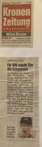 Ein Zeitungsausschnitt mit einem Artikel über den Radrennfahrer Tim, der sich für die Weltmeisterschaft besonders anstrengt, mit einem Kopfbild von Tim, das eine Mütze und Sportkleidung trägt. Der Artikel stammt aus der Kronen Zeitung, datiert vom 17. Juni 2023.