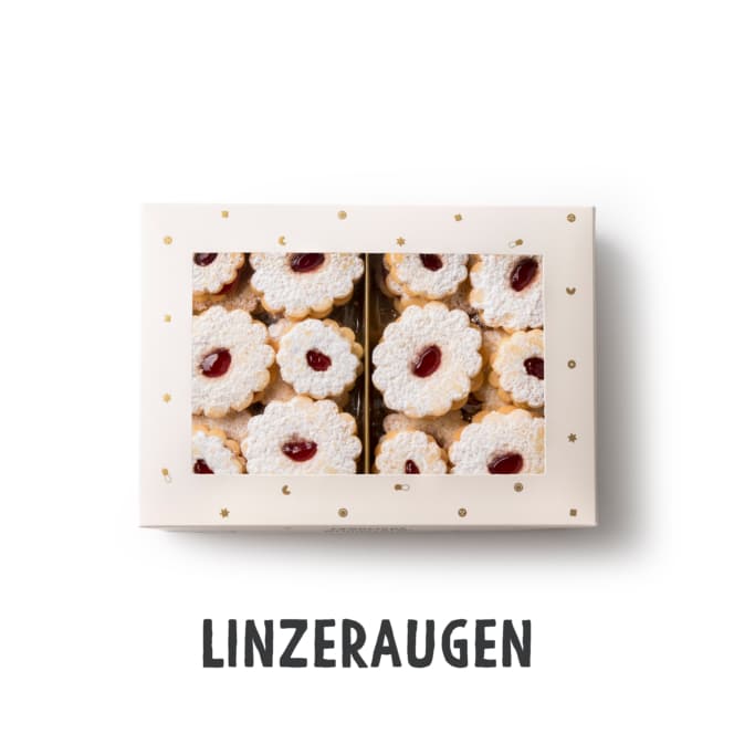 Eine Schachtel Linzeraugen-Kekse, fein säuberlich in Reihen angeordnet. Die Kekse sind rund, mit Puderzucker bestäubt und haben in der Mitte eine kleine Ausstanzung, die mit roter Marmelade gefüllt ist. Das Wort LINZERAUGEN steht unter der Schachtel.