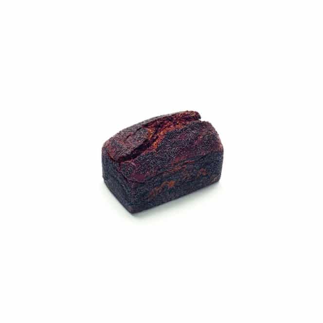 Ein einzelner Laib dunkles, knuspriges Brot mit einer rissigen Oberseite liegt auf einem weißen Hintergrund.
