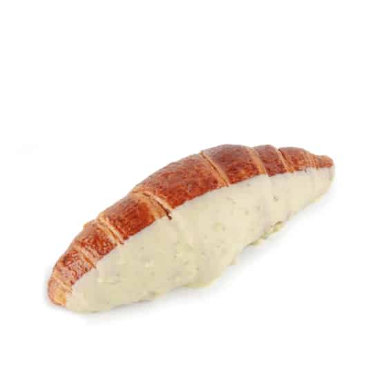 Ein goldbraunes Croissant, das teilweise in eine dicke Schicht aus weißer Soße oder Zuckerguss getaucht ist und auf einem schlichten weißen Untergrund liegt.