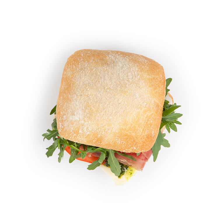 Ein quadratisches Ciabatta-Sandwich mit sichtbarem Rucola, Tomate, Käse und Pökelfleisch, von oben gesehen auf einem weißen Hintergrund.