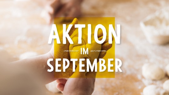 Hände, die auf einer bemehlten Fläche Teig kneten, überlagert von einem gelben Quadrat und weißem Text mit der Aufschrift AKTION IM SEPTEMBER (Werbung im September).