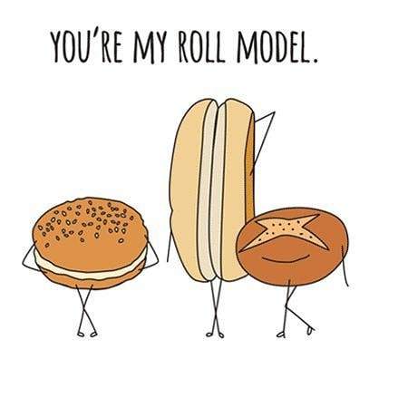 Drei Cartoon-Brötchen mit Armen und Beinen stehen zusammen unter dem Text YOURE MY ROLL MODEL. Eines sieht aus wie ein Hamburger-Brötchen, eines ist ein Hot-Dog-Brötchen und das letzte ist ein rundes Brötchen mit einem X oben drauf.