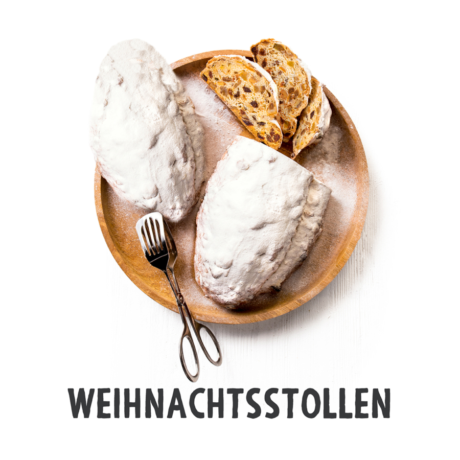 Ein Holzteller mit zwei mit Puderzucker bestäubten Stollen und mehreren Scheiben, daneben eine alte Zange. Unter dem Teller steht in fetten Lettern das Wort WEIHNACHTSSTOLLEN.