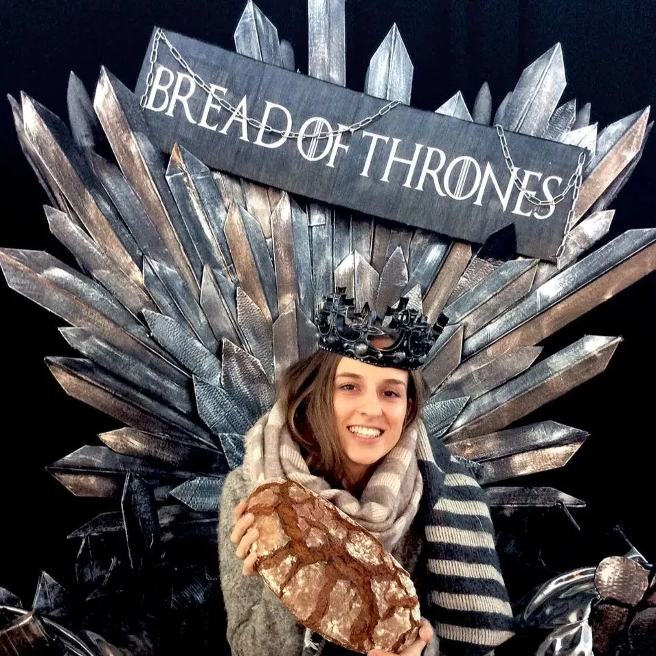 Eine Frau mit Krone und Kopftuch sitzt auf einem Thron aus Metallschwertern. Sie lächelt und hält einen Laib Brot in der Hand. Über ihr prangt ein Schild mit der Aufschrift "BREAD OF THRONES", eine Anspielung auf Game of Thrones.