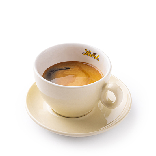 Eine Tasse Espresso mit einer cremigen Cremaschicht, serviert in einer hellbeigen Tasse mit passender Untertasse. Auf dem Innenrand der Tasse steht in gelber Schrift das Wort "Strich". Der Hintergrund ist einfarbig weiß.