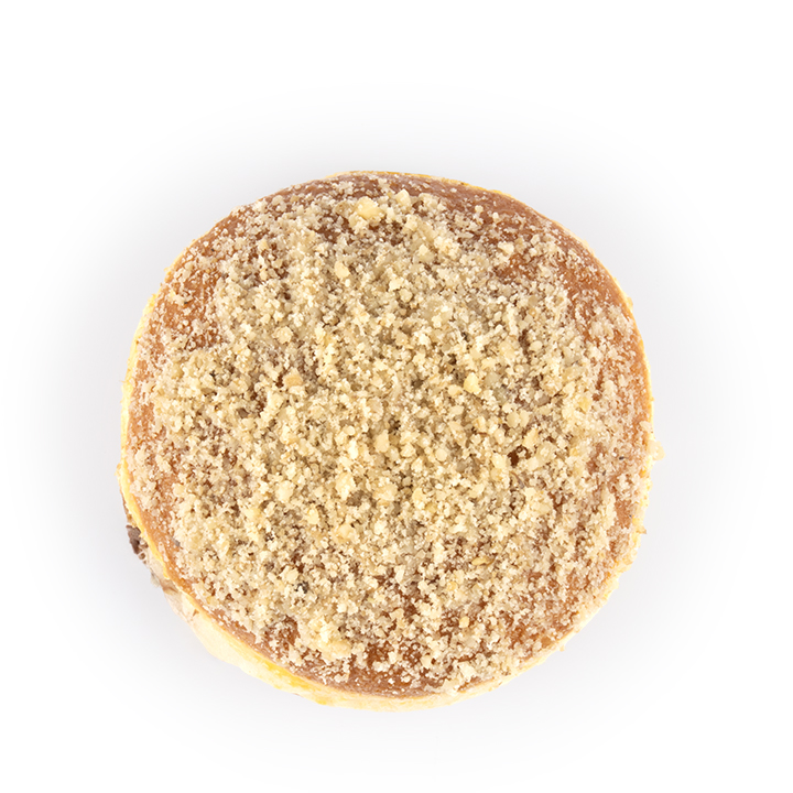 Eine Ansicht von oben auf einen runden Donut, der mit einer Schicht aus feinen Krümeln oder zerkleinerten Nüssen bedeckt ist, vor weißem Hintergrund.