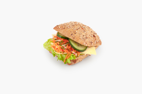 A multigrain sandwich bun filled with lettuce, shredded carrots, cheese, cucumber slices, and fresh herbs, isolated on a white background.