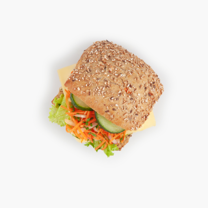 A sandwich with multigrain bread, lettuce, shredded carrots, cucumber slices, and cheese, photographed from above on a white background.