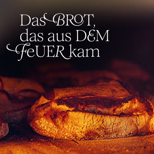 Zwei rustikale Brotlaibe, die in einem Ofen backen, mit einer warmen, goldbraunen Kruste. Der überlagerte deutsche Text lautet: Das BROT, das aus DEM feUER kam.