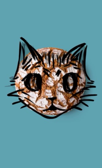 Ein runder Laib Brot auf einem blaugrünen Hintergrund mit schwarzen Linien, die an ein Katzengesicht, Ohren und Schnurrhaare erinnern.
